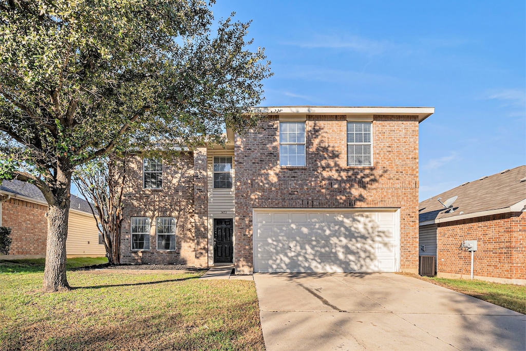 front of property with a garage, central air condition unit, and a front yard