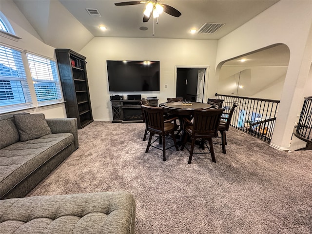 carpeted dining space with vaulted ceiling and ceiling fan