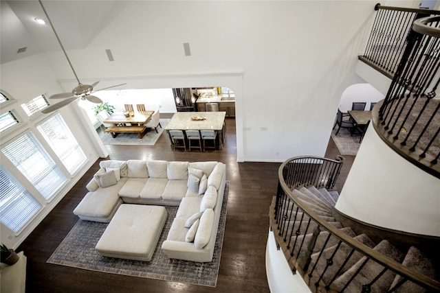 living room with dark wood-type flooring, high vaulted ceiling, and ceiling fan