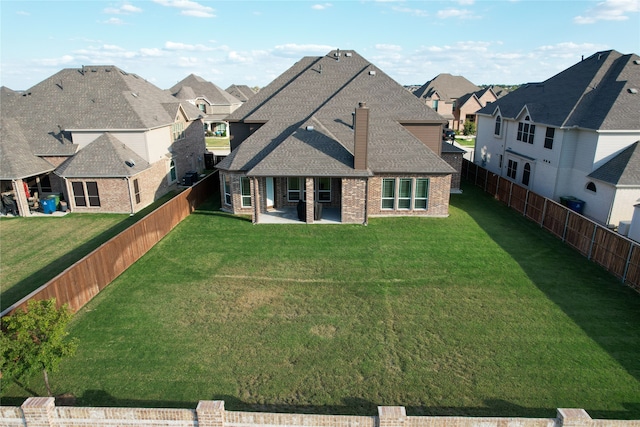 rear view of property featuring a patio and a lawn