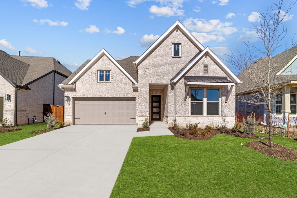 view of front of property featuring a front lawn and a garage