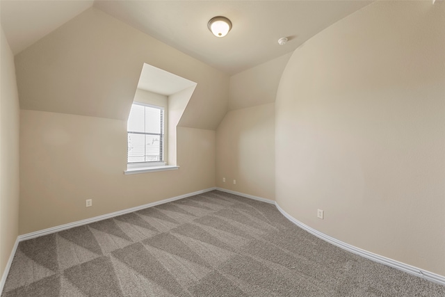 additional living space with vaulted ceiling and carpet floors