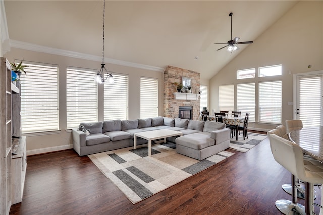 living room featuring high vaulted ceiling, dark hardwood / wood-style floors, a fireplace, ceiling fan with notable chandelier, and crown molding