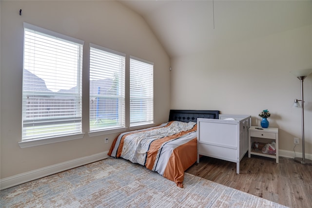 bedroom with lofted ceiling and light wood-type flooring