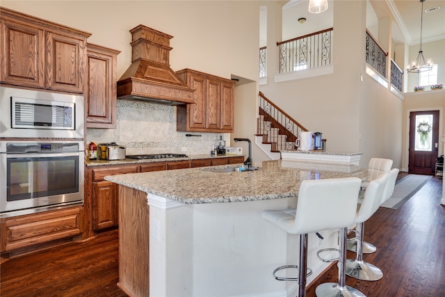 kitchen featuring appliances with stainless steel finishes, dark hardwood / wood-style flooring, a breakfast bar, and an island with sink