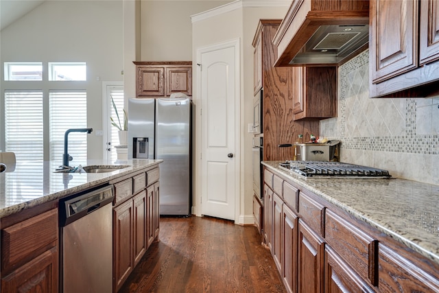 kitchen featuring light stone countertops, appliances with stainless steel finishes, sink, custom exhaust hood, and dark wood-type flooring