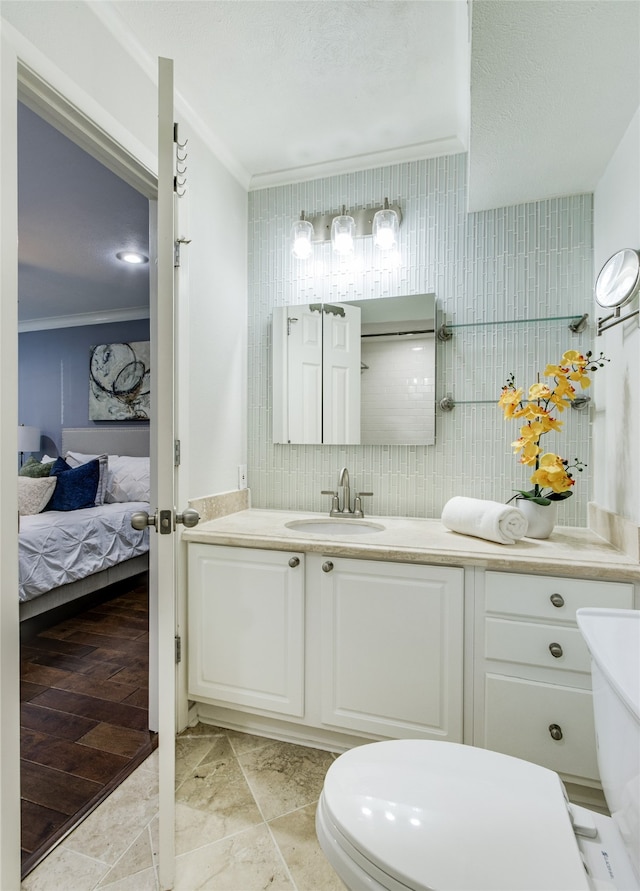 bathroom with a textured ceiling, vanity, crown molding, hardwood / wood-style flooring, and toilet