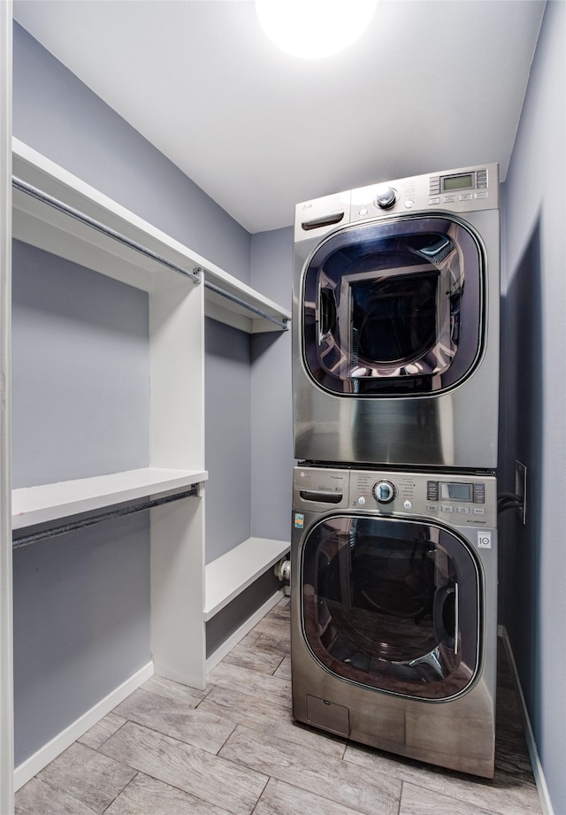 washroom featuring stacked washer / drying machine and light hardwood / wood-style flooring