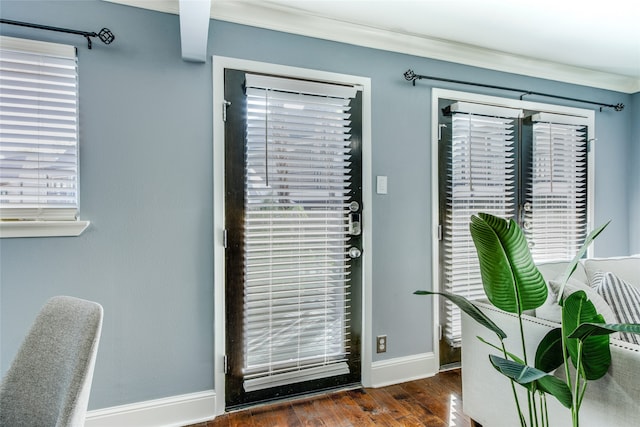 doorway to outside with crown molding, dark wood-type flooring, and a healthy amount of sunlight