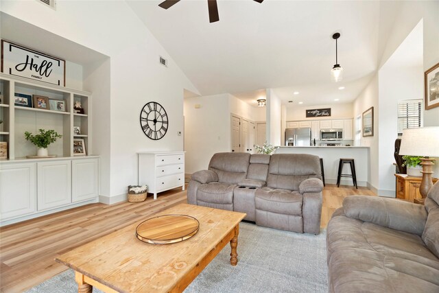 living room with ceiling fan, high vaulted ceiling, and light wood-type flooring