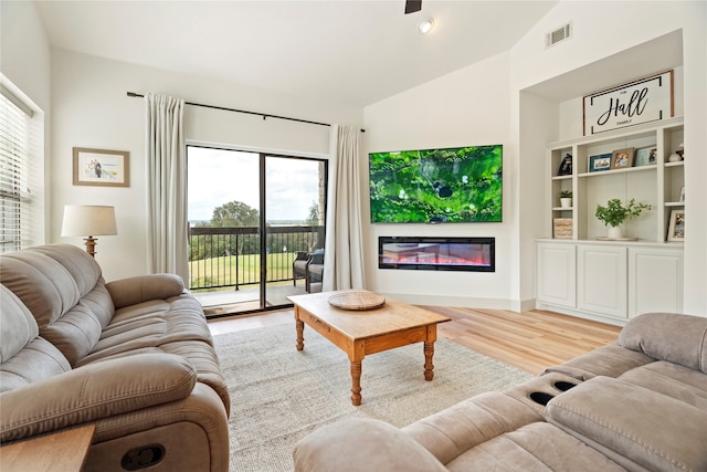 living room featuring light wood-type flooring and vaulted ceiling