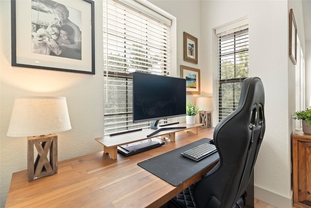 home office featuring a textured wall and wood finished floors