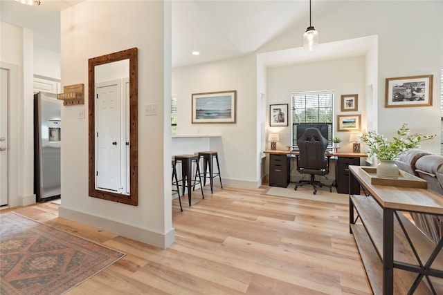 office with high vaulted ceiling, baseboards, and light wood finished floors