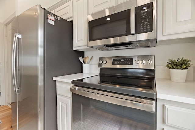 kitchen featuring hardwood / wood-style flooring, white cabinetry, and appliances with stainless steel finishes