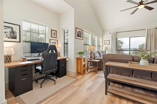 office area featuring high vaulted ceiling, light wood finished floors, and a ceiling fan