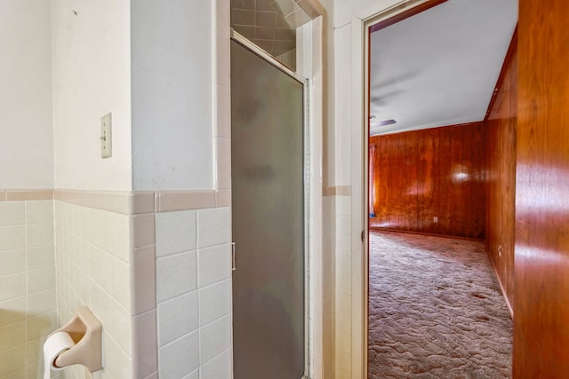 bathroom with a shower with door and wooden walls