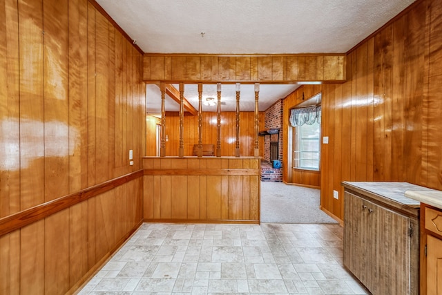 interior space featuring a textured ceiling, wooden walls, and light colored carpet