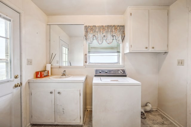 clothes washing area with washer / dryer, sink, and cabinets