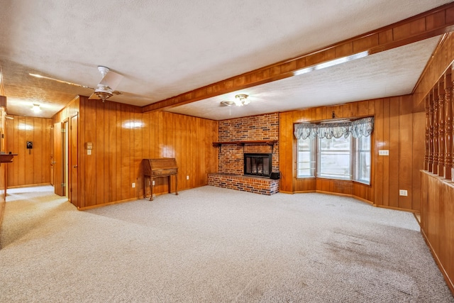 unfurnished living room with a textured ceiling, wooden walls, and light colored carpet