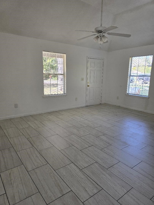 spare room featuring a textured ceiling, a healthy amount of sunlight, and ceiling fan