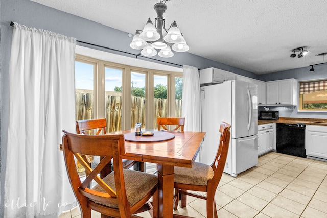 dining space featuring an inviting chandelier, a textured ceiling, light tile patterned floors, and plenty of natural light