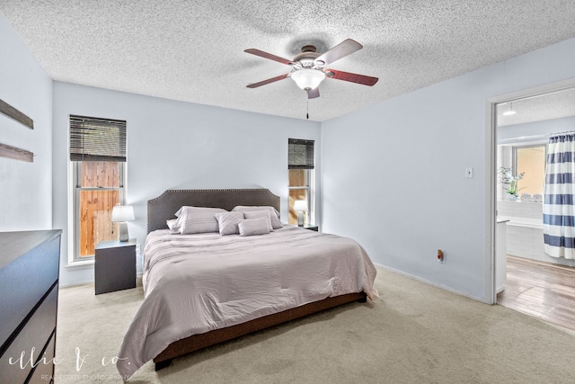 bedroom with a textured ceiling, light colored carpet, and ceiling fan