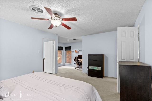 bedroom featuring light carpet, a textured ceiling, and ceiling fan