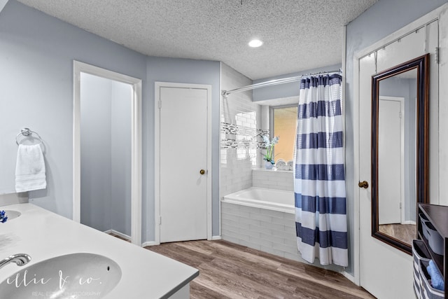 bathroom with vanity, hardwood / wood-style floors, shower / tub combo, and a textured ceiling