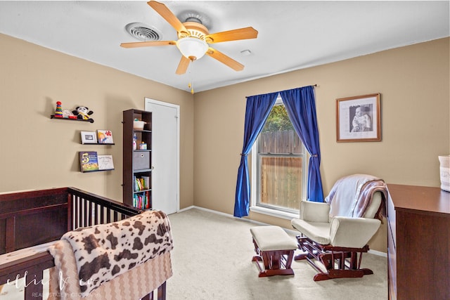 bedroom featuring carpet floors, a crib, and ceiling fan