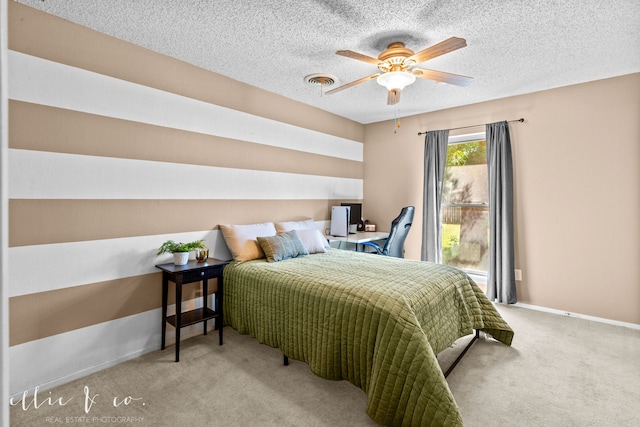 carpeted bedroom featuring ceiling fan and a textured ceiling