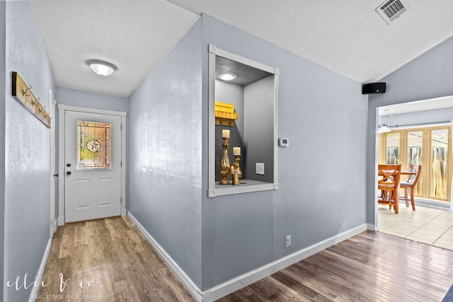 corridor featuring lofted ceiling and hardwood / wood-style floors