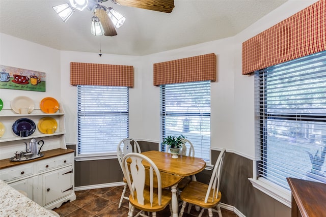 tiled dining room with ceiling fan and a textured ceiling