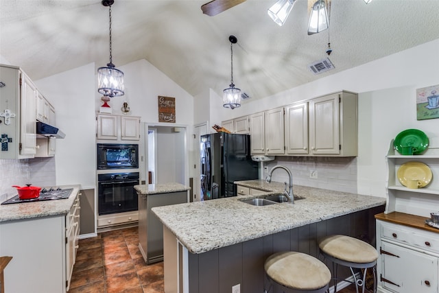 kitchen with sink, black appliances, light stone countertops, and hanging light fixtures