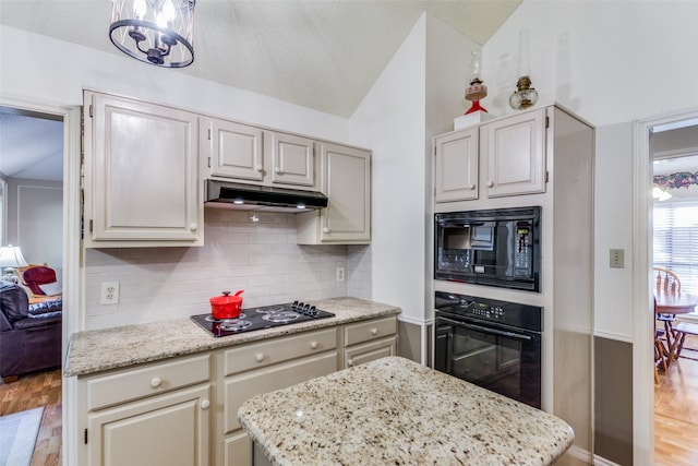 kitchen featuring sink, a center island, hanging light fixtures, and black appliances