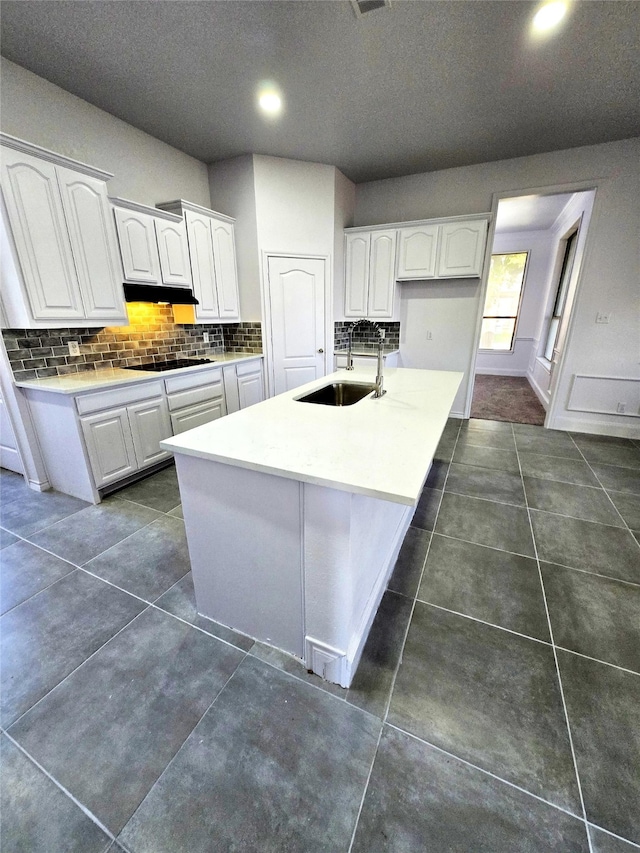 kitchen featuring white cabinetry, backsplash, sink, and dark tile patterned floors