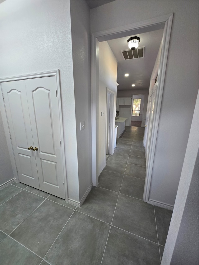 hall with dark tile patterned floors