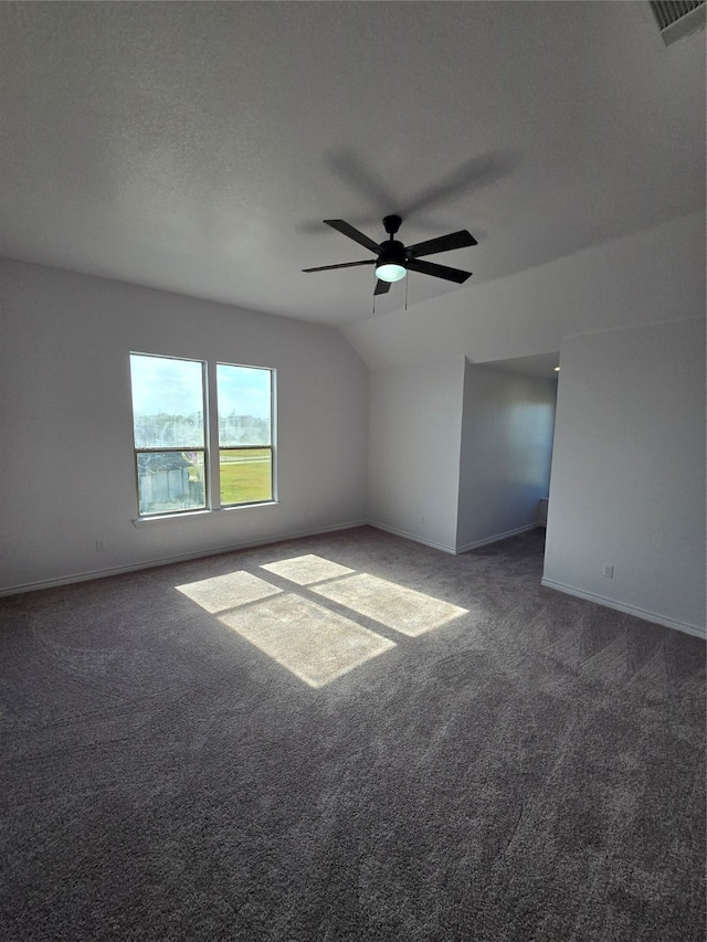 additional living space with ceiling fan, a textured ceiling, vaulted ceiling, and dark carpet