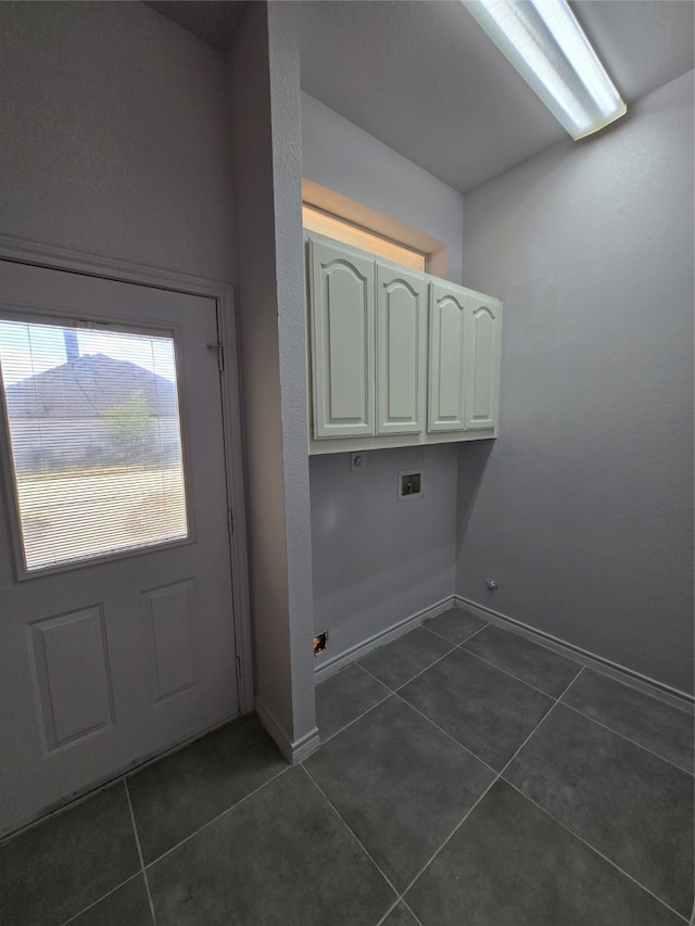 washroom featuring hookup for a washing machine, cabinets, and dark tile patterned floors