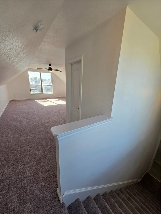 bonus room featuring a textured ceiling, vaulted ceiling, carpet floors, and ceiling fan