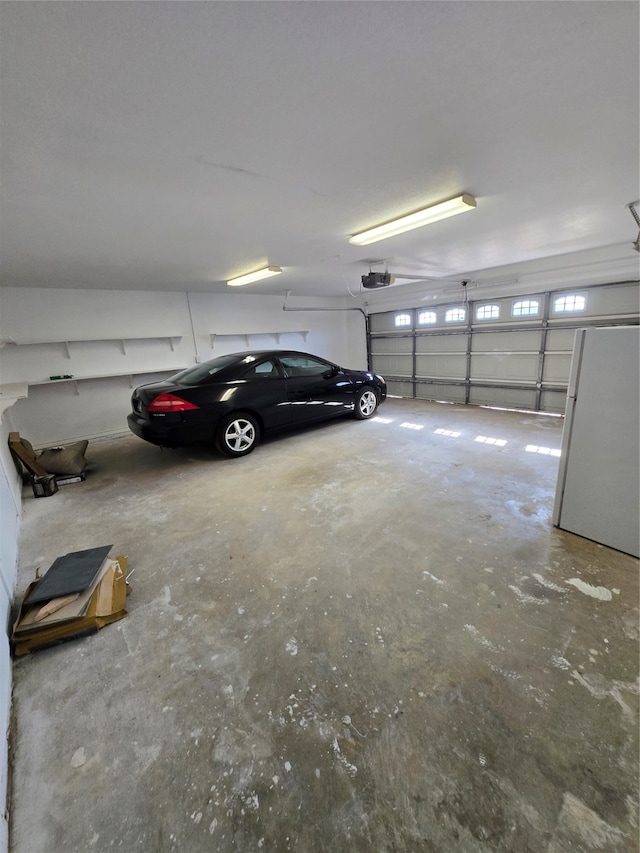 garage featuring a garage door opener and white fridge