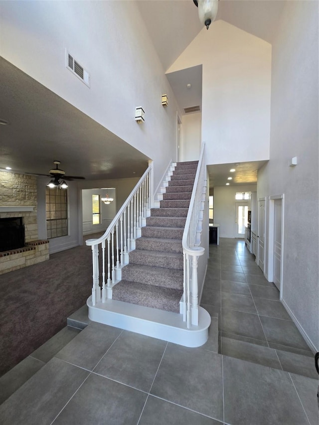 16536 County Road 221, Forney, TX 75126 - stairway with ceiling fan, tile patterned floors, a fireplace, and a towering ceiling