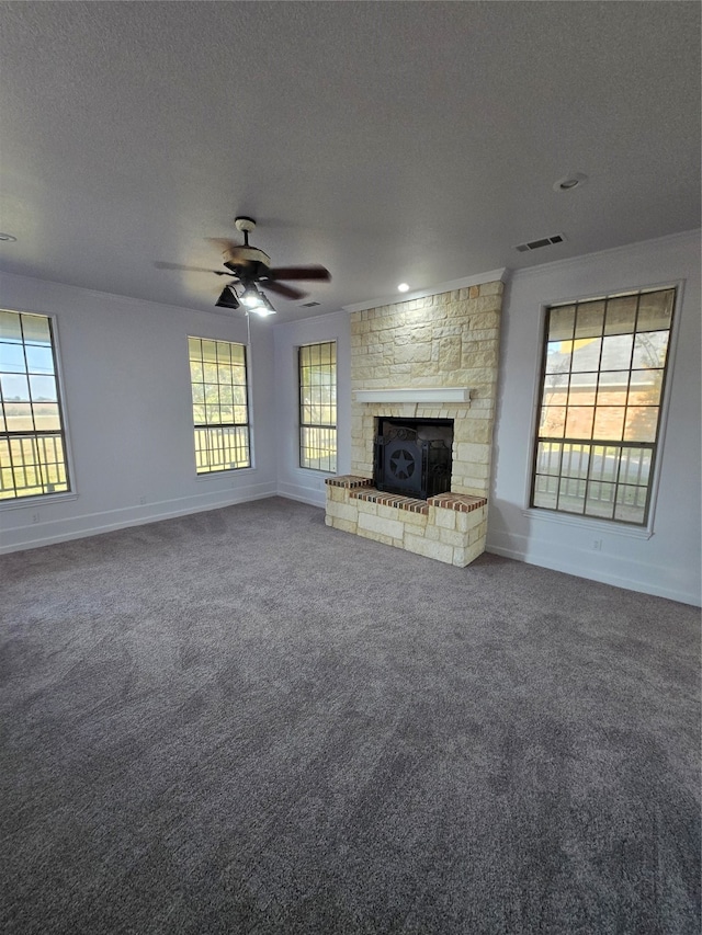 unfurnished living room featuring carpet, a textured ceiling, a fireplace, and ceiling fan