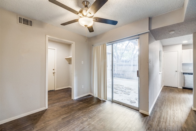 doorway featuring dark wood-type flooring, a textured ceiling, and ceiling fan