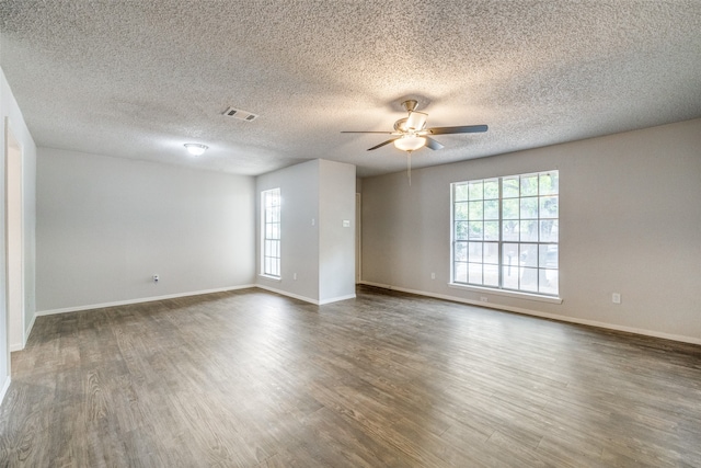 empty room featuring dark wood-type flooring, a textured ceiling, and ceiling fan