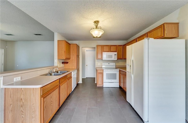 kitchen featuring sink, a textured ceiling, tile patterned floors, and white appliances