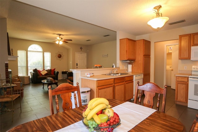 dining space with ceiling fan, a fireplace, and sink