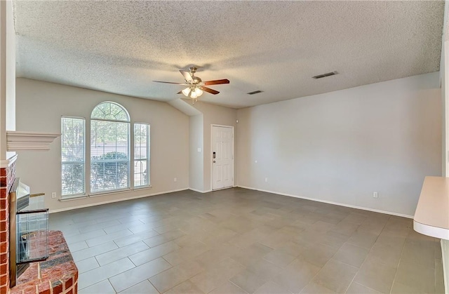 interior space featuring a brick fireplace, a textured ceiling, and ceiling fan