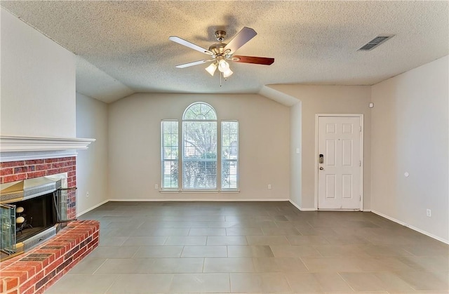 unfurnished living room with a brick fireplace, a textured ceiling, lofted ceiling, and ceiling fan