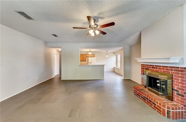 unfurnished living room with ceiling fan, a fireplace, and a textured ceiling