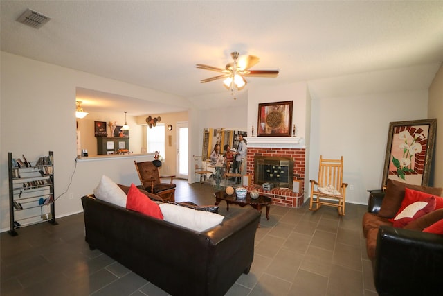 living room with dark tile patterned floors, a brick fireplace, and ceiling fan